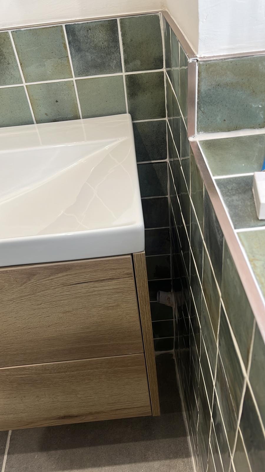 Close-up of neat tile edges and trim beside the vanity