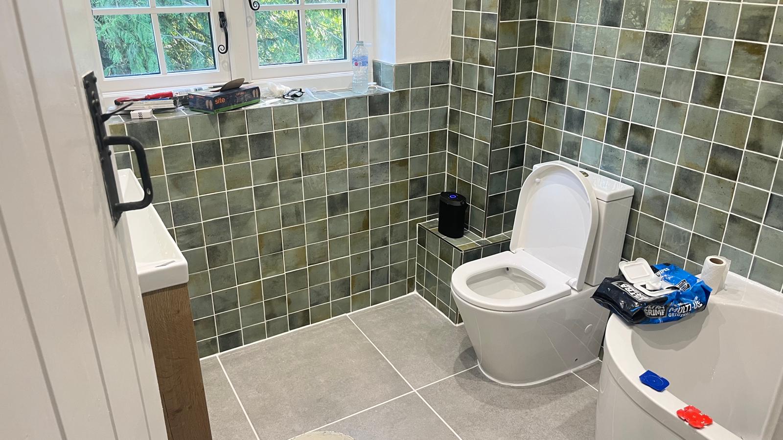 Bathroom nearly finished with tiled walls, toilet and bath