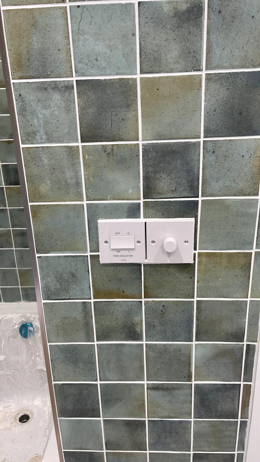Tiles cut neatly around wall switches