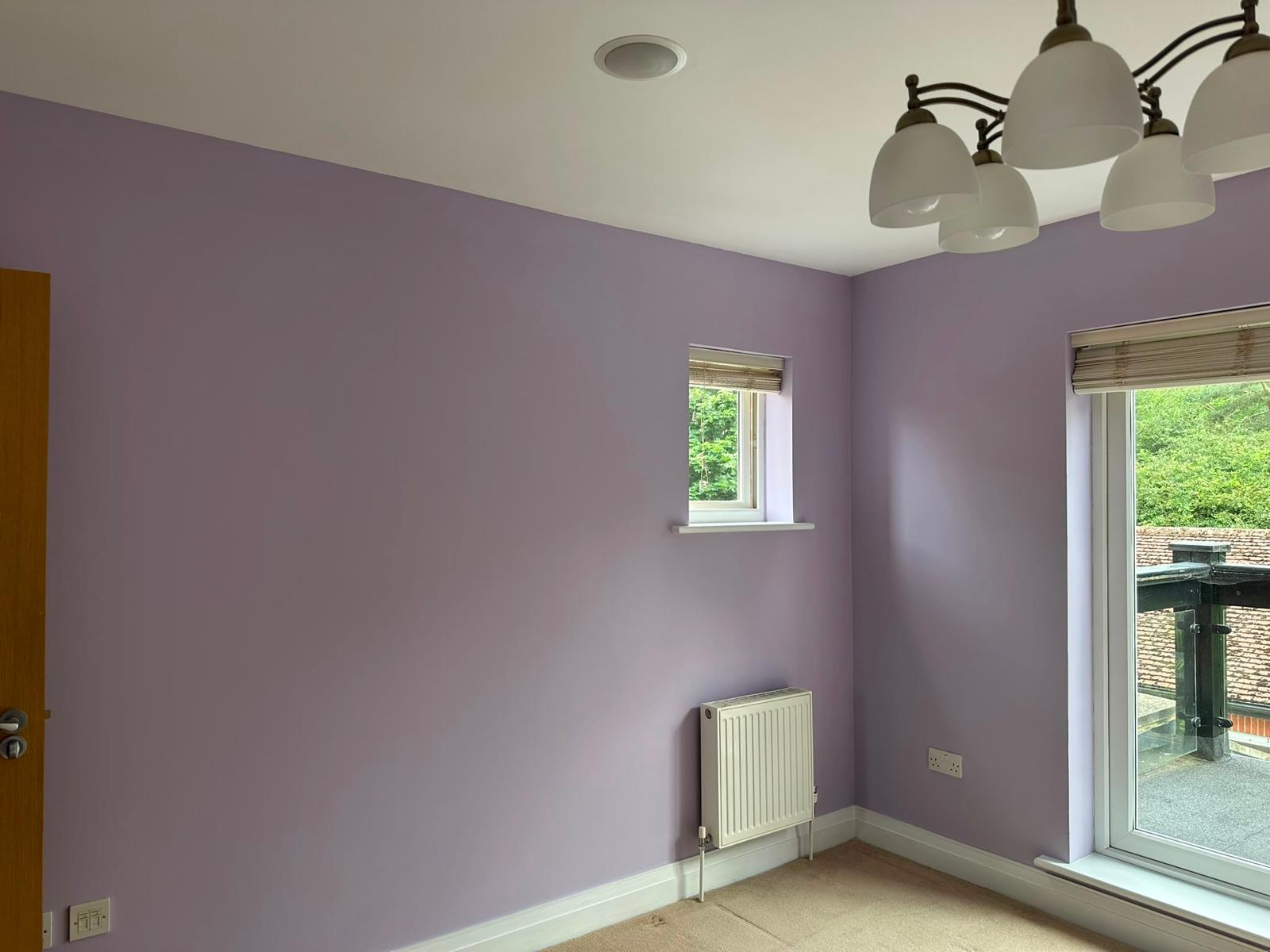 Bedroom painted lilac with white ceiling and skirting