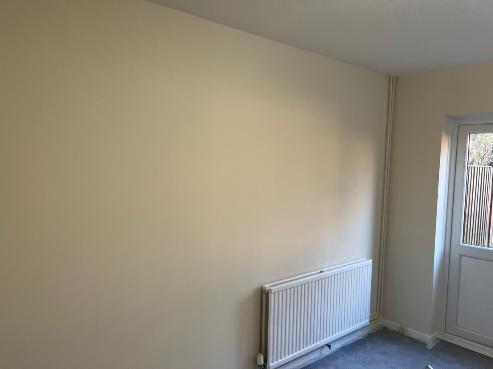 Bedroom wall with a smooth cream finish above the radiator