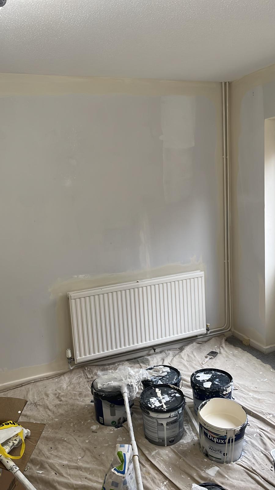 Wall patch-filled before painting, with paint tins on dust sheets