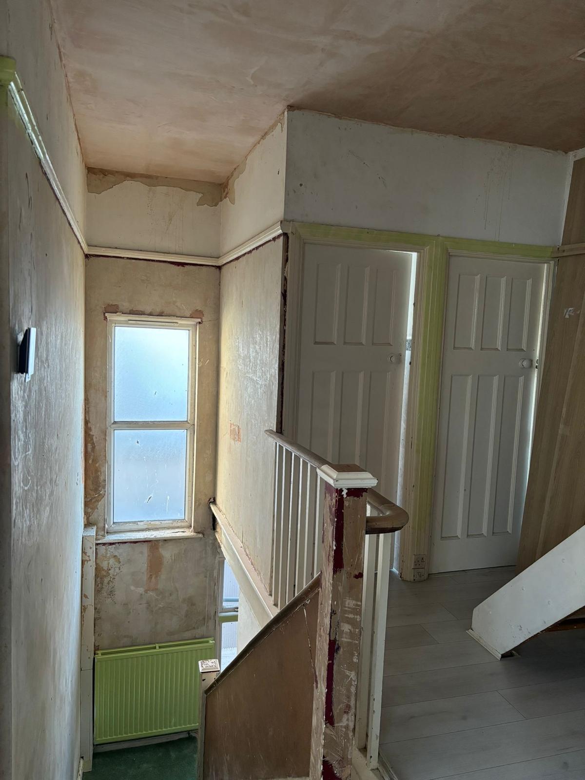 Before photo of the stairwell with damaged walls and ceiling