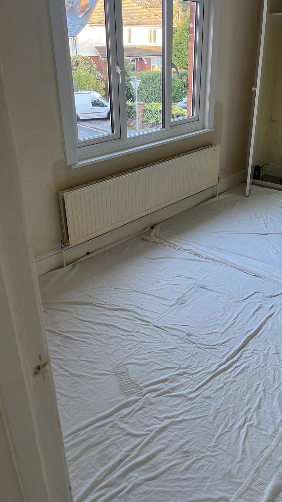 Bedroom floor covered with dust sheets before painting